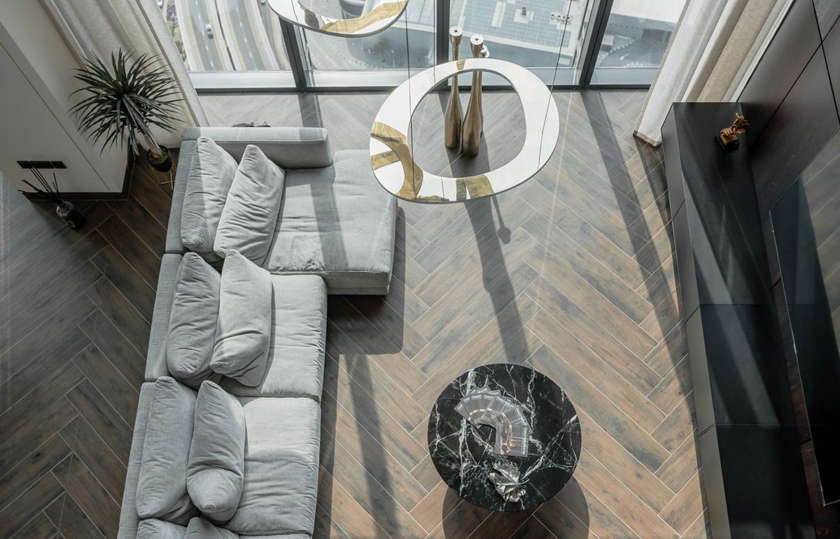 Visualisation of Marina Apartment 02, a living room with a low sofa on herringbone oak, a concept by NU Projects