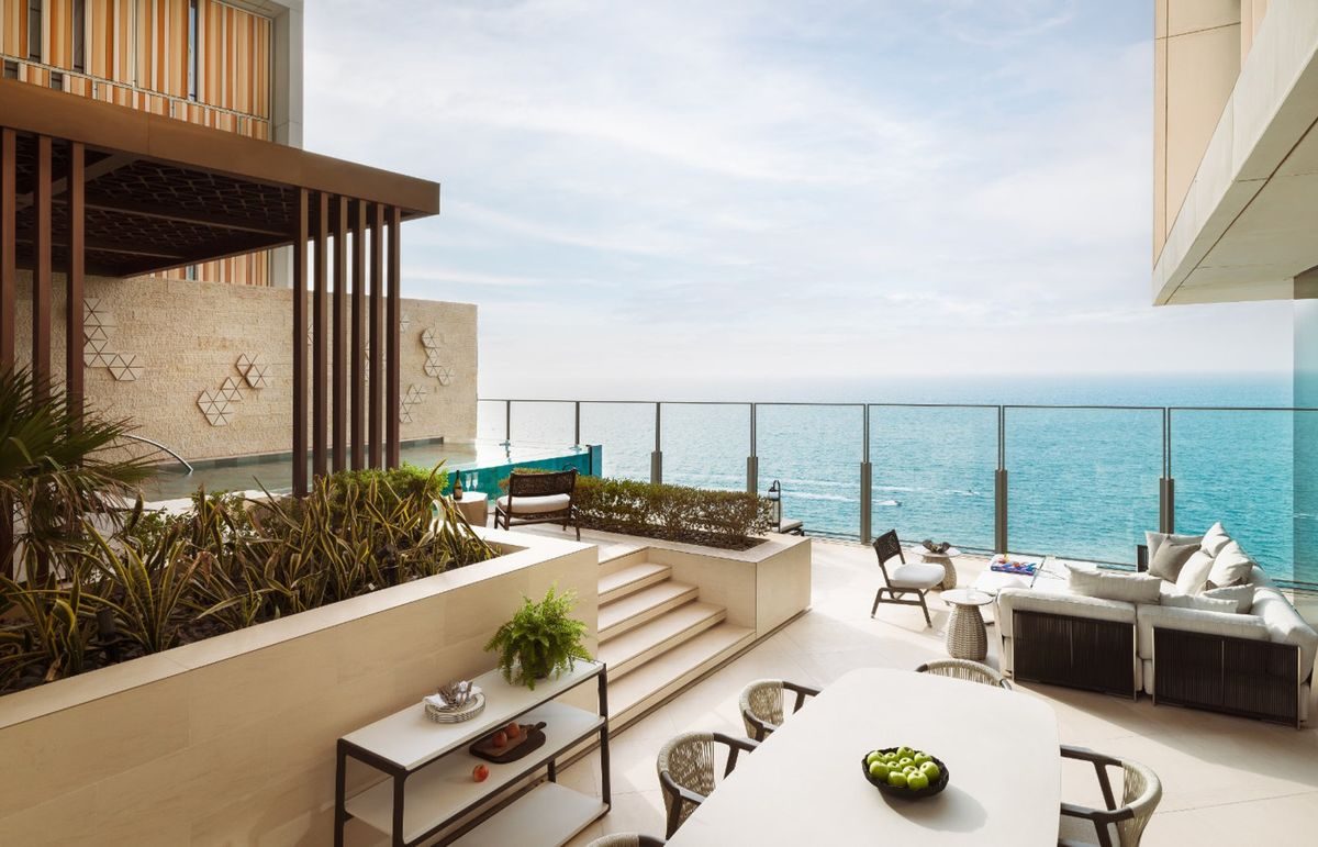 Visualisation of a shaded villa terrace under a timber pergola, with a pool meeting the sea
